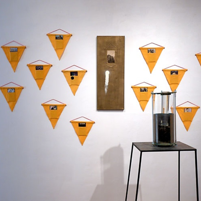 Patrik Kovačovský: Vyžarovanie, 2004 - 2016 /textilné zástavky na označovanie výbušnín, sololit, tlač a akryl/ a Svetlo dopadajúce na krajinu, 2015, kombinovaná technika